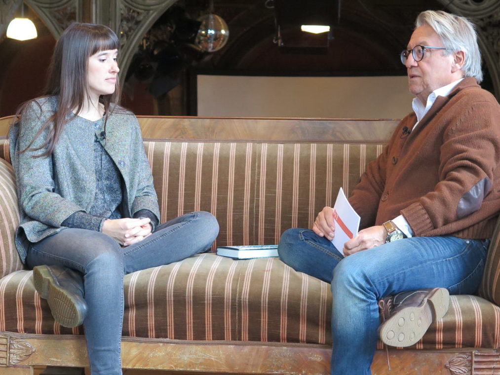 H1 Interview mit Ada Dorian mit Michael Hertrampf. Beide sitzen auf einem Sofa im Treppenhaus in Hannover.